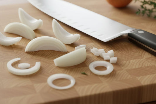 A chef's knife lying on a cutting board with chopped onions.
