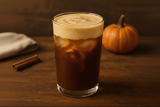Pumpkin cream cold brew in a tall glass on a wooden table.
